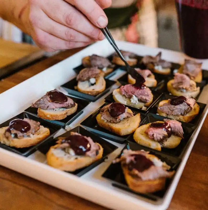 Chef plating gourmet appetizers for a birthday appetizer party with Chefski